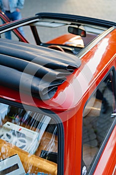 A red retro car with a convertible roof and leather seats.