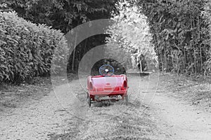 Red retro child car on the country road.