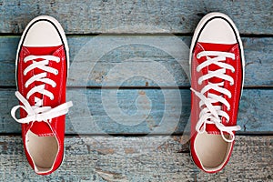 Red retro sneakers on a blue wooden background