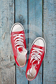 Red retro sneakers on a blue wooden background