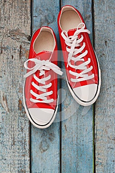 Red retro sneakers, close-up, on a blue wooden background