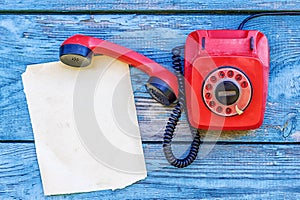 Red retro telephone and a sheet of paper for records