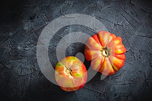 Red ribbed tomato cuore di bue on a dark background top view