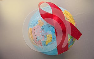 The red ribbon on the background of the globe is an international symbol of struggle, a symbol of compassion, support and hope for