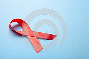 Red ribbon on blue background. Cancer awareness, HIV, AIDS concept