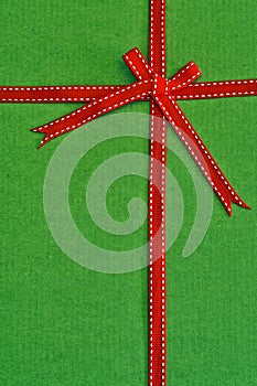 Red ribbon and bow over green