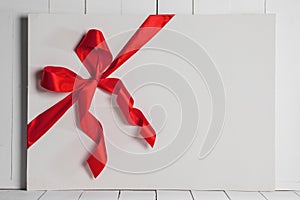 Red ribbon bow on white board