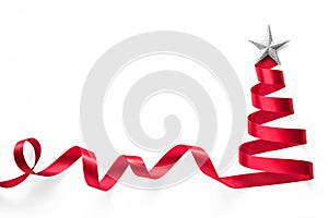 Red ribbon Christmas tree made of satin bow scroll with silver star isolated on white background with clipping path for xmas
