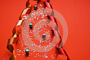 Red ribbon and glitter stars on a red background. balls for decorating the tree