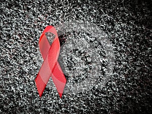 Red ribbon on granite, world aids day concept