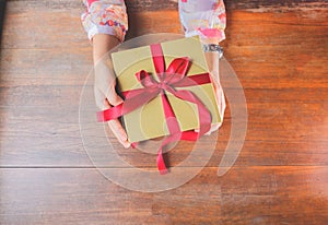 The red ribbon present or gift box in woman hands. Christmas or birthday present and thanksgiving, more give the more receive