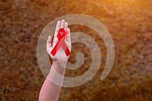Red Ribbon in women hands for World AIDS day concept