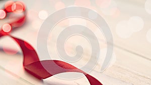 red ribbon on wood background for valentines day with bokeh blurred effect copy space  curly swirls of red silk  elegant  s