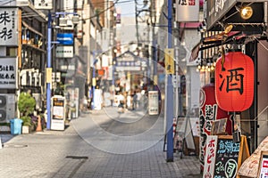 Red rice paper lantern with japanese kanji sake which mean Alcool on the front of an restaurant in the shopping street from the