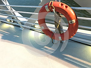 Red ring lifebuoy on a white cruise ship with deep-sea in the background