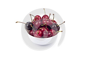 Red ripe Cherries in white bowl isolated on white