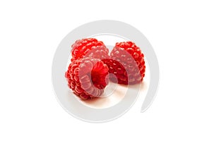 Red ripe fresh raspberries on white surface