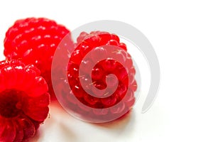 Red ripe fresh raspberries on white surface close-up