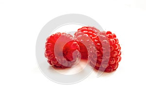 Red ripe fresh raspberries on white surface close-up