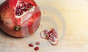 Red ripe pomegranate on wooden cutting board. Fresh open ruby garnet on table. vitamin and diet concept