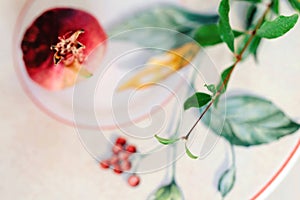 Red ripe pomegranates with green leaves on ornamental plate background, Copy space, top view.
