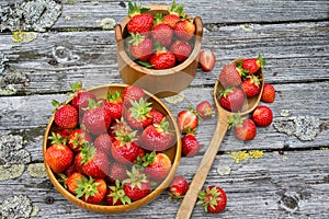 Red ripe strawberries in a wooden basket on the old boards