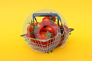 Red ripe tomatoes lie in a decorative basket on an isolated background.