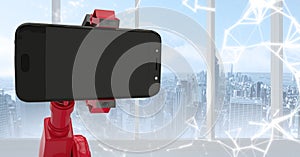 Red robot claw holding phone against white interface and window with skyline