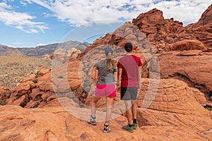 Red Rock Canyon - Couple standing on rocks with scenic view of Aztec sandstone slickrock outcrop on the Calico Hills Tank Trail