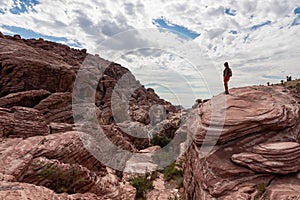 Red Rock Canyon - Woman standing on edge of rock formation with scenic view of limestone rock of Calico Hills, Nevada, USA