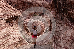 Red Rock Canyon - Woman standing in gorge of rock formation with scenic view of limestone rock of Calico Hills, Nevada, USA