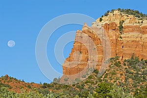 Red rock formation with full moon