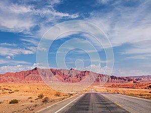 The red rock formations of Danxia landform with empty highway in Xinjiang of China