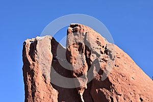 Red rock outcropping against a blue sky in winter with snow.