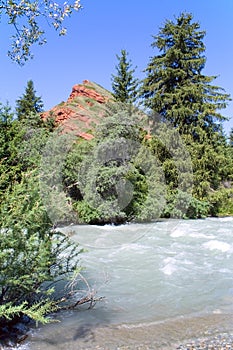 Red Rock over the fast mountain river