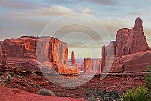 Red rock spires below a cloudy sky in Arches National Park.