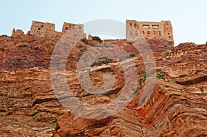 Red rocks and decorated old houses on the road to Kawkaban, Yemen