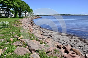 Red rocks and green grass along shore of Charlottetown Harbour