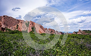 Red rocks in the green park with clouds photo