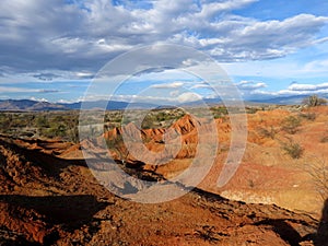 Red rocky hills and cloudy blue sky