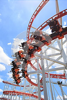 Red roller coaster rail with blue sky in background