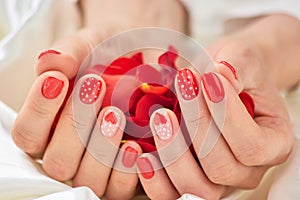 Red romantic manicure and petals.