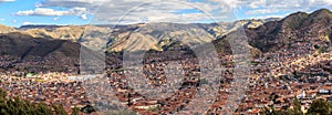 Red roof houses of Cuzco city in the valley and Andes panorama,