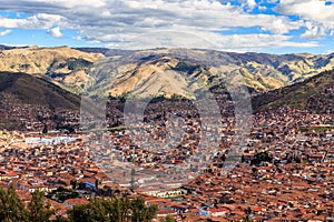 Red roof houses of Cuzco city in the valley and Andes panorama,