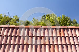 Red roof tile pattern over blue sky.