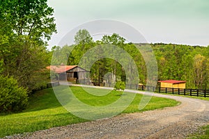 A red-roofed barn on the farm in the spring.