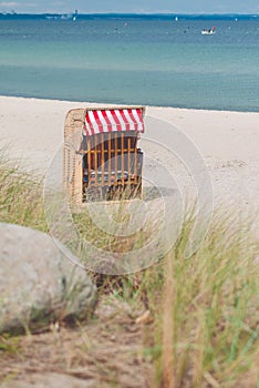 Red roofed chair on sandy beach in Travemunde, North Germany