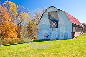 Red roofed white barn with quilts in West Virginia