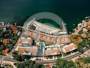 Red roofs of the Huma Kotor Bay hotel and villas with private beach and swimming pool. Dobrota, Montenegro. Top view