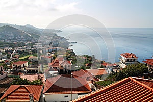 Red roofs of Madeira houses near the ocean